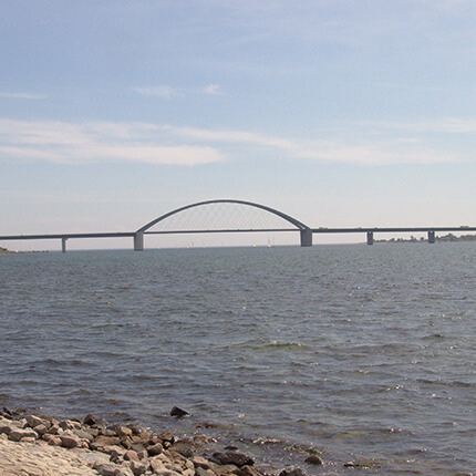 Ein Bild von der Fehmarnsundbrücke mit Ostsee und Steinen
