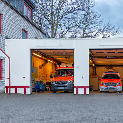 Ein Bild von den Fahrzeughallen der Rettungswache Timmendorfer Strand mit RTW und NEF