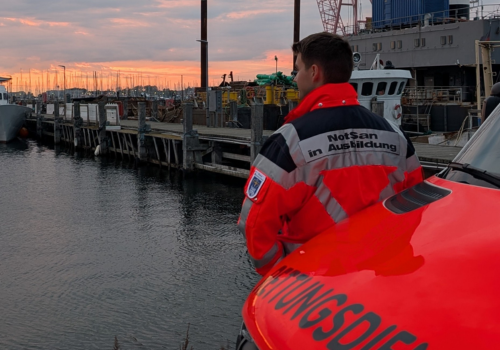Azubi steht mit RTW vor dem Hafen